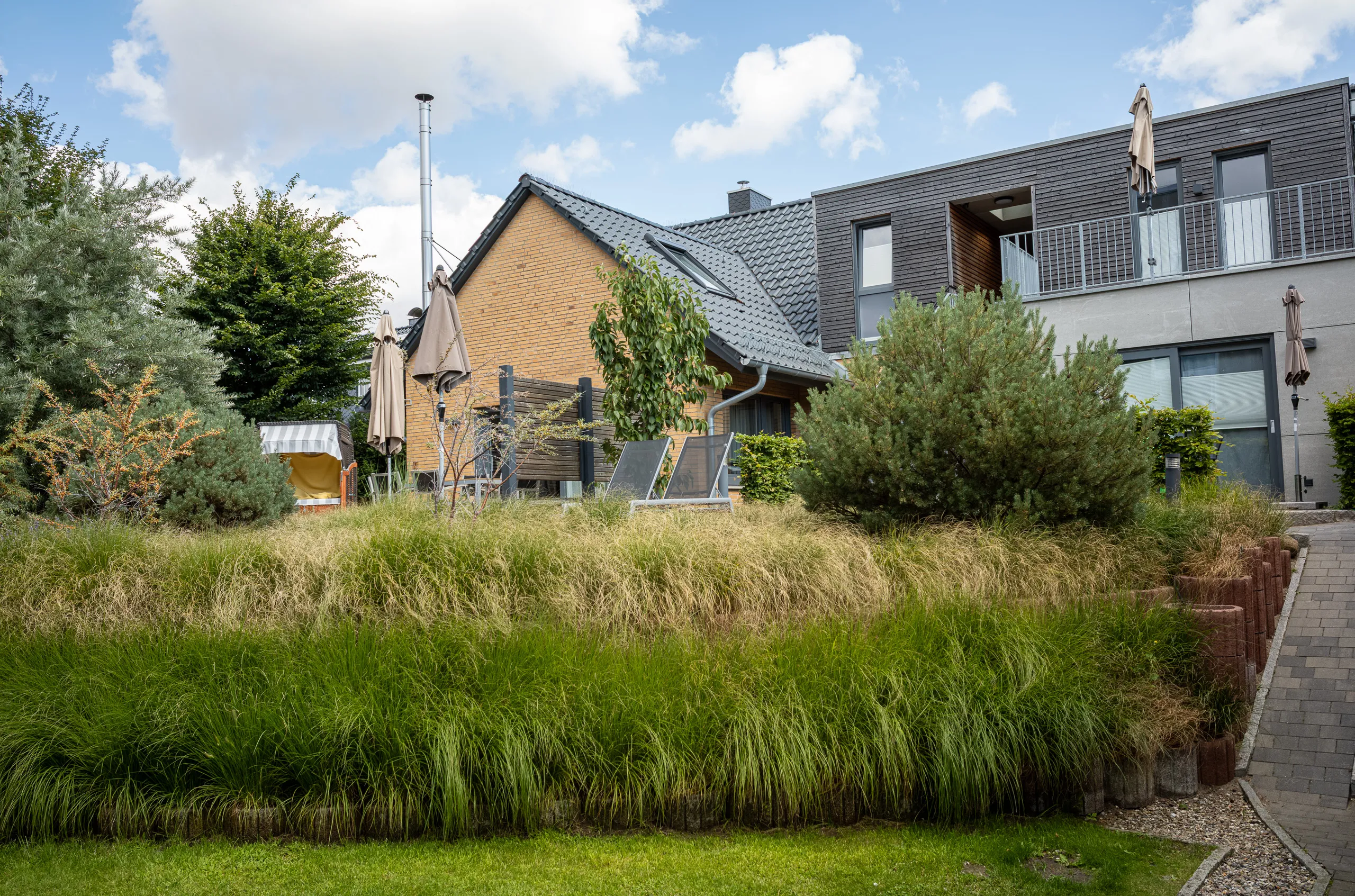 Garten mit Gräsern und Liegestühlen